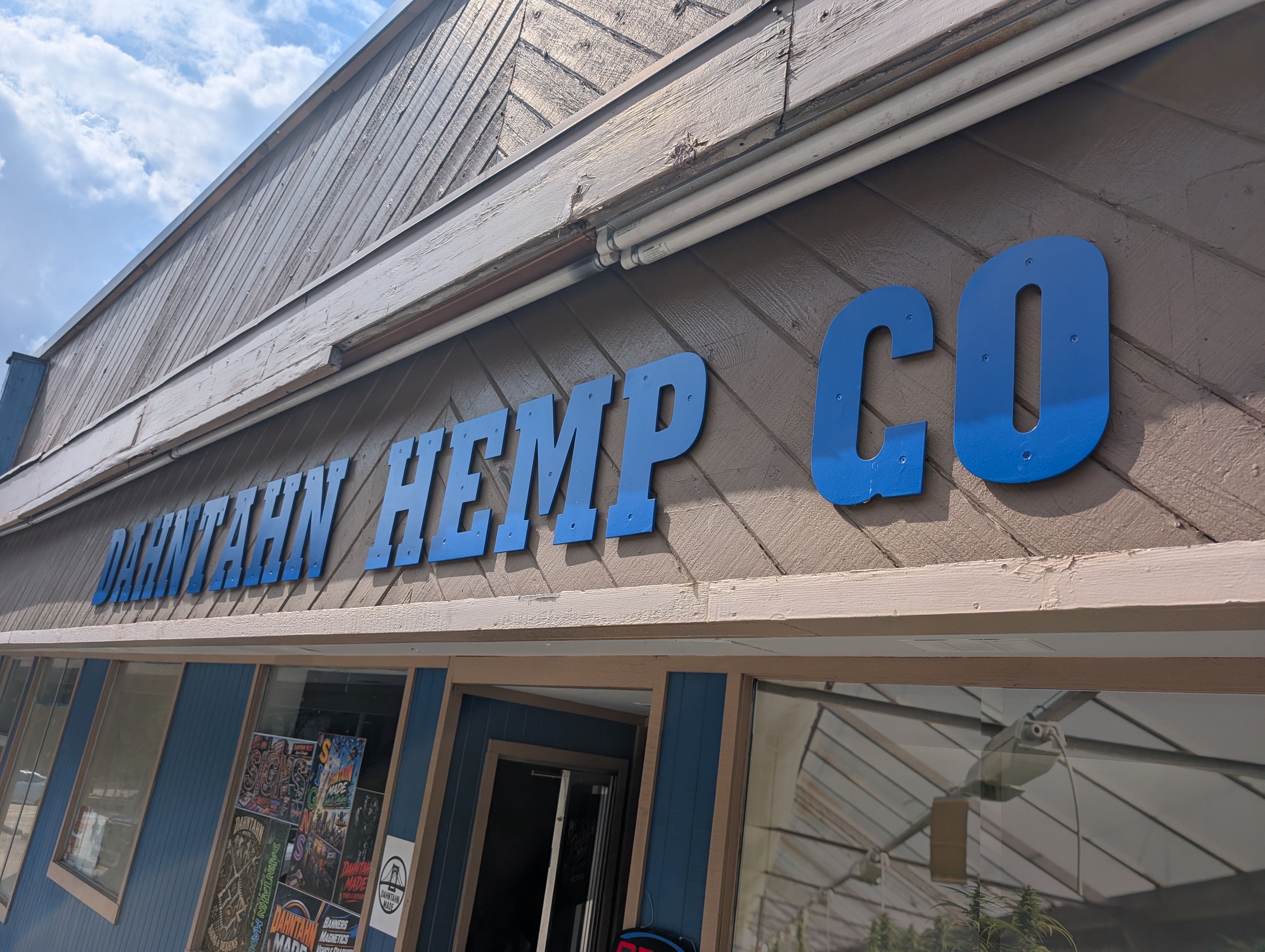 Installed blue dimensional Dahntahn Hemp Co. storefront lettering on a commercial building